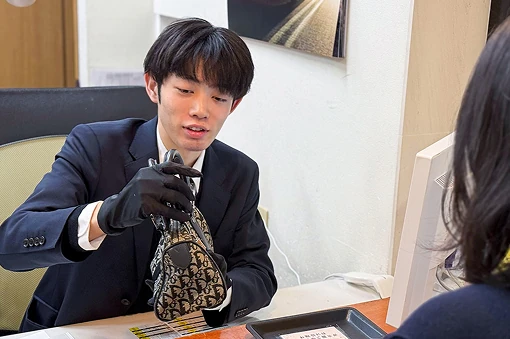 バッグを査定する鑑定士